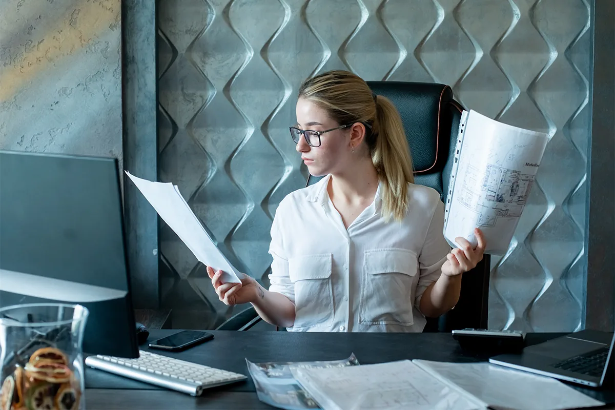 insert-obieg-dokumentow-praca-z-dokumentami-w-biurze Pracownica biura analizująca dokumenty przy komputerze – elektroniczny obieg dokumentów w programie Insert